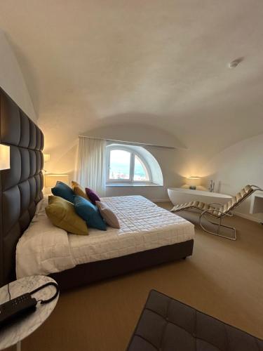 a bedroom with a bed with pillows and a window at Palazzo Ferraioli - Hotel & Wellness in Atrani