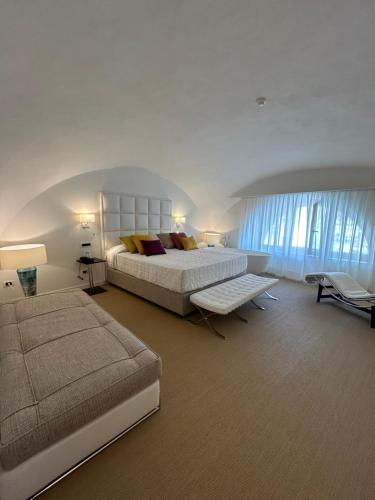 a large bedroom with a bed and a couch at Palazzo Ferraioli - Hotel & Wellness in Atrani