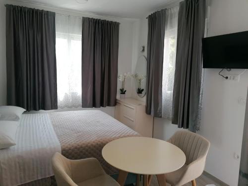 ポドストラナにあるApartments and Rooms Tomasのベッドルーム1室(ベッド1台、テーブル、椅子付)