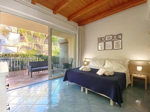 een slaapkamer met een bed en een balkon bij Grand Bleu Magarà in Cefalù