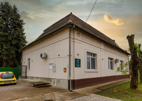 a small white building with a car parked next to it at Vila Bor in Bečej