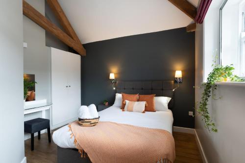 a bedroom with a large bed and a black wall at High Street Town House in Manchester