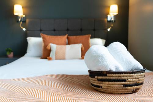 a bedroom with a bed with a basket of towels at High Street Town House in Manchester