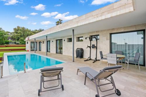 un patio con piscina, sillas y mesa en Villa de Lujo Welcs PDA 073 con Piscina y Vistas al Mar, en Platja d'Aro