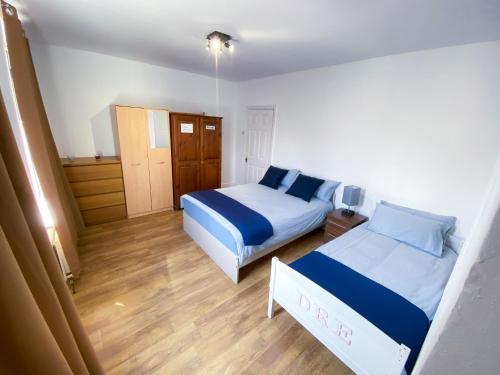 - une petite chambre avec 2 lits et du parquet dans l'établissement 4 BEDROOM HOUSE PARKING & GARDEN NEAR CENTRAL LONDOn, à Londres