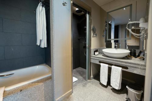 a bathroom with a tub and a sink at Barceló León Conde Luna in León