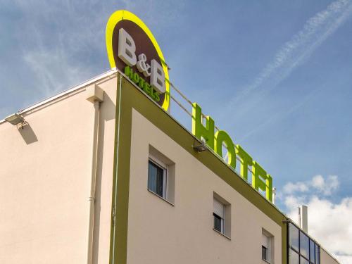 a building with a sign on the top of it at B&B HOTEL Clermont-Ferrand Sud Aubière in Aubière