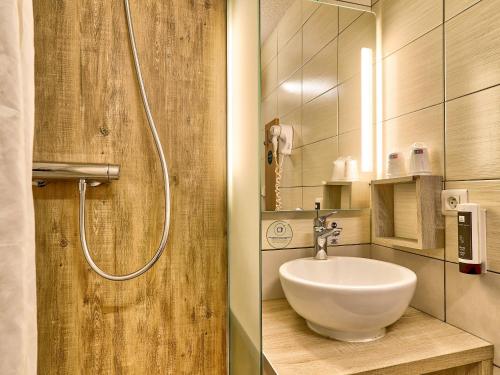 La salle de bains est pourvue d'un lavabo et d'une douche. dans l'établissement B&B HOTEL Clermont-Ferrand Sud Aubière, à Aubière