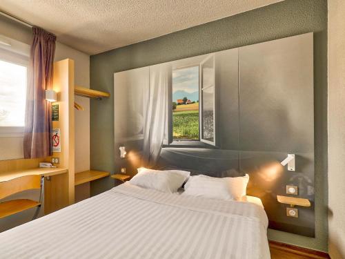 - une chambre avec un grand lit et une fenêtre dans l'établissement B&B HOTEL Clermont-Ferrand Sud Aubière, à Aubière