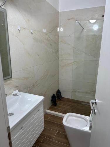 a bathroom with a sink and a shower and a toilet at Espana aparthotel in Durrës