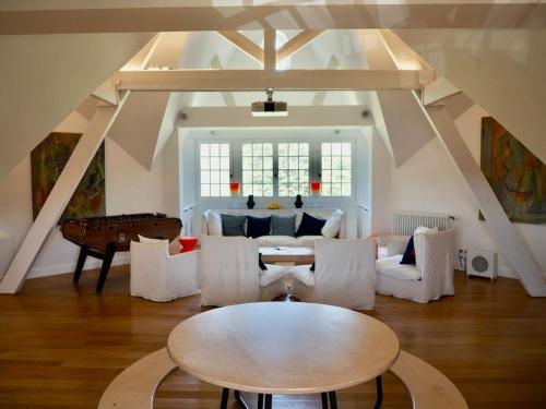 a living room with a table and a piano at Manoir au coeur du triangle d or au Touquet in Le Touquet-Paris-Plage