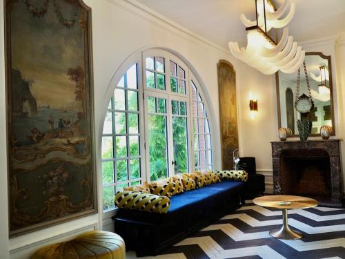 a living room with a couch and a large window at Manoir au coeur du triangle d or au Touquet in Le Touquet-Paris-Plage