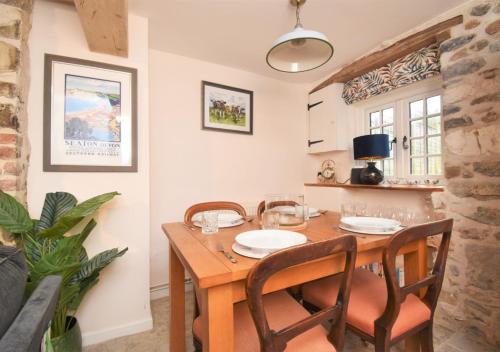 a dining room with a wooden table and chairs at Bluebell Cottage - Seaton in Seaton