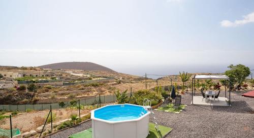 a pool in a backyard with a view of the ocean at La Casa del Barranco in Fasnia