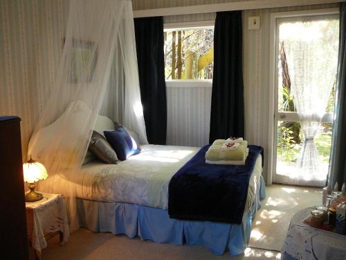a bedroom with a bed and a window at Mount Tutu Eco-Sanctuary in Ohauiti