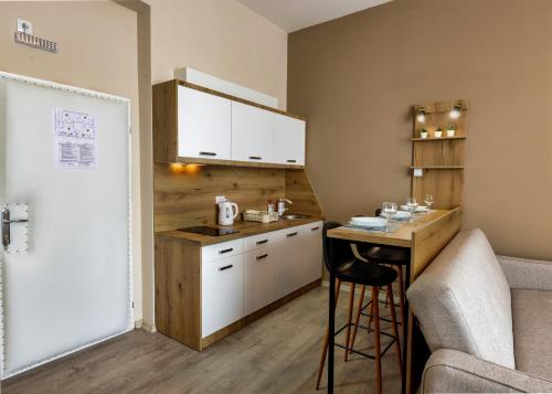 a small kitchen with a counter and a table at Vila Bor in Bečej
