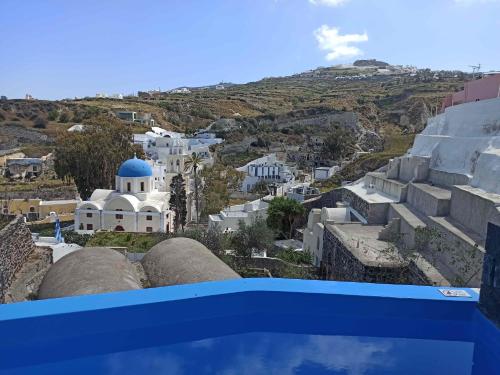a view of a city from the balcony of a building at Amphitrite Suites Santorini in Vóthon