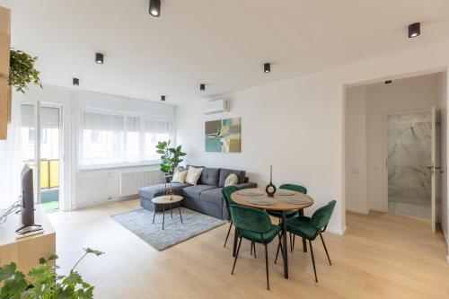 Una sala de estar con un sofá, una mesa y sillas. en Gems of Budapest - Emerald Suite, en Budapest