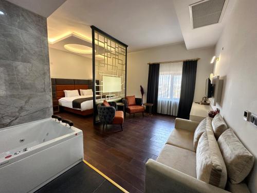 Midyat Royal Hotel & Spa في مِديات: غرفة في الفندق مع أريكة وسرير وحوض استحمام