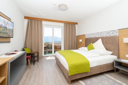 um quarto de hotel com uma cama grande e uma secretária em Hotel-Café-Restaurant Matzelsdorfer Hof em Millstatt
