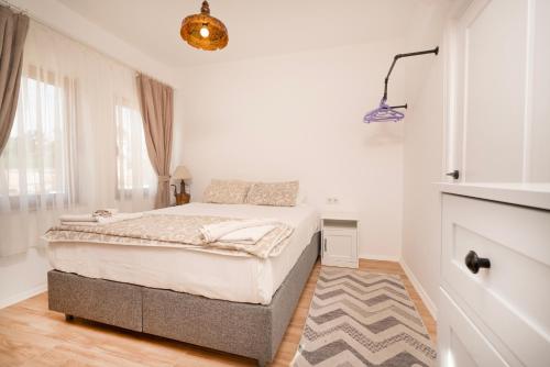 a white bedroom with a bed and a window at Beach House Hotel in Side