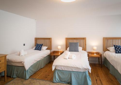 um quarto com duas camas e duas lâmpadas nas mesas em Ravenswell em Dartmouth