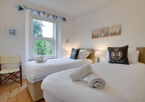 um quarto com 2 camas e uma janela em 4 Thurlestone Court em Dartmouth