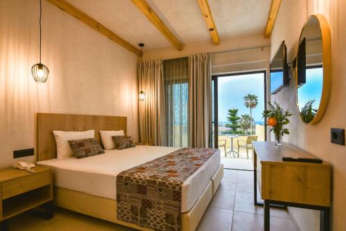 a bedroom with a bed and a desk and a window at Despo Hotel in Gouves
