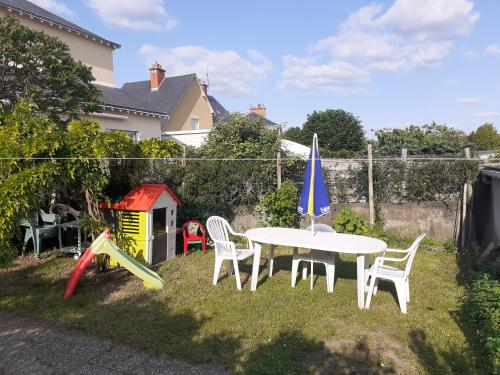 a backyard with a table and chairs and a play set at Loue chambre chez l habitant 24h du Mans voiture in Le Mans