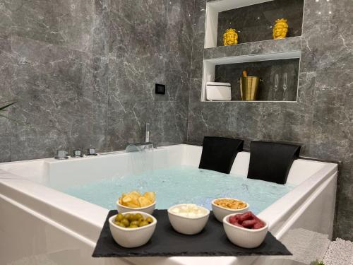 Una bañera llena de agua con cuencos de comida. en FUDDIA Room & Suite, en Palermo