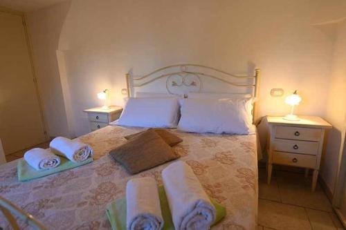 a bedroom with a large bed with towels on it at Trullo Antico with exclusive swimming pool in Cisternino