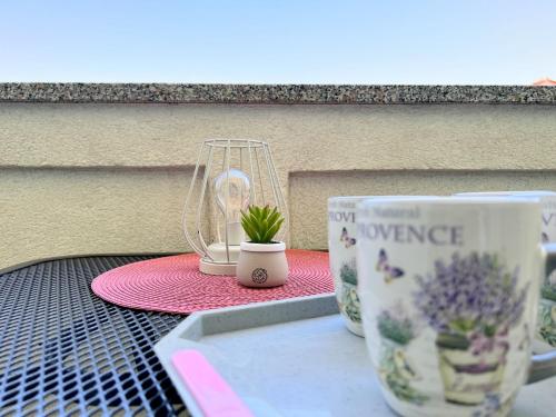 a table with two cups and a plant on it at Rab City Apartment Greeny in Rab
