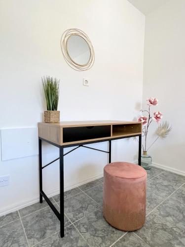 a desk with a round mirror and a stool at Rab City Apartment Greeny in Rab