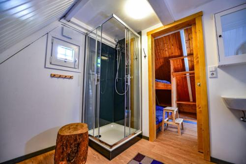 a bathroom with a shower and a wooden floor at Nordic Ferienpark Sorpesee in Sundern