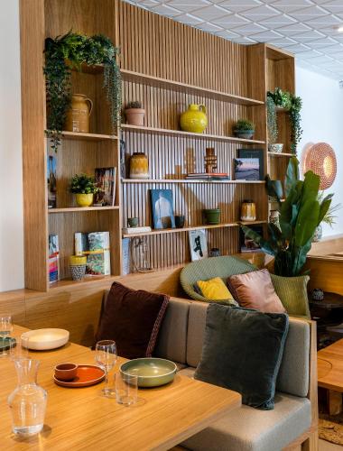 a living room with a table and a couch and shelves at Domaine Les Sources de Dieulefit in Dieulefit
