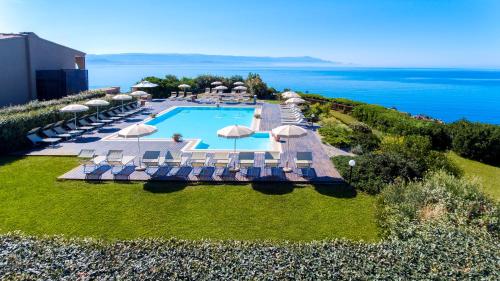 una vista aerea di un resort con piscina e ombrelloni di Hotel Dei Pini a Fertilia