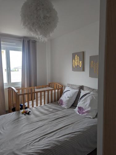 a bedroom with a bed and a window at Chez Nonna in Jonage