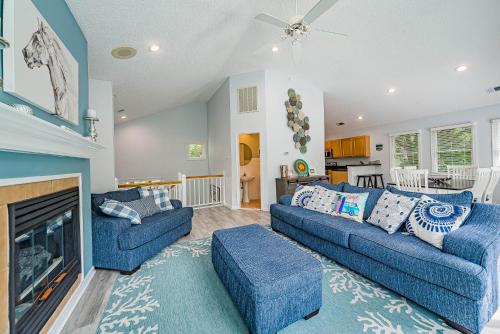 a living room with two blue couches and a fireplace at Currituck Carl's in Sanderling