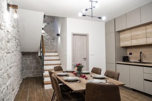 a kitchen and dining room with a wooden table and chairs at Holiday Home Vrkic with Hot Tub in Omiš