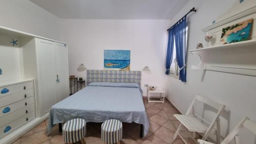 ein kleines Schlafzimmer mit einem Bett und einem Stuhl in der Unterkunft Betty vacanze in Badesi