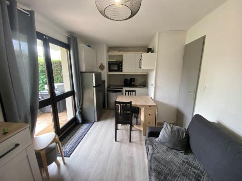 een woonkamer met een bank en een tafel en een keuken bij Cabourg - Appartement - 4 pers - 1 ch - Piscine in Cabourg