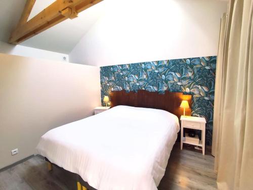 una camera con un letto bianco e una parete blu di La Salixienne maison 6/7 pers a Saulcy-sur-Meurthe
