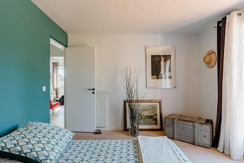 - une chambre avec un lit bleu et un mur blanc dans l'établissement Séjour en Provence Maison avec Vue sur la Sainte Victoire et Piscine près d'Aix en Provence, à Aix-en-Provence