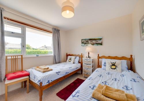 two beds in a bedroom with a window at Island View in Thurlestone