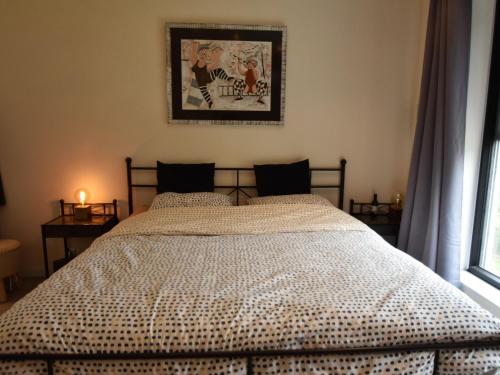 uma cama num quarto com uma fotografia na parede em Modern holiday home in Maasmechelen with sauna em Maasmechelen