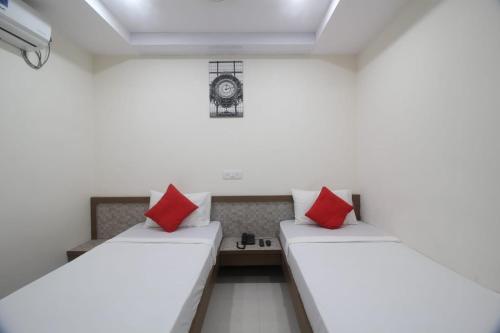 - 2 lits dans une chambre avec des oreillers rouges dans l'établissement Arjuna Luxury Rooms, à Hyderabad