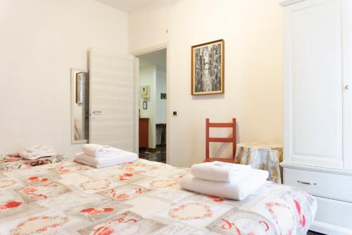 1 dormitorio con 1 cama con toallas en Re Lear - 4 bedrooms Apartment, en Verona