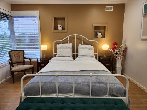 1 dormitorio con cama de metal con sábanas y almohadas blancas en Spacious Frankston Retreat, en Frankston