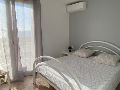 une chambre avec un lit blanc et une fenêtre dans l'établissement Calvi Lumio location face mer, à Lumio