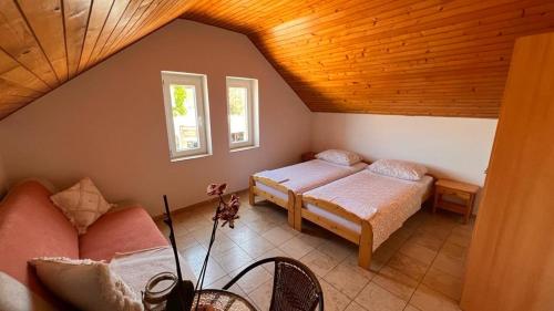 a attic bedroom with two beds and a couch at Apartment 39 in Vir